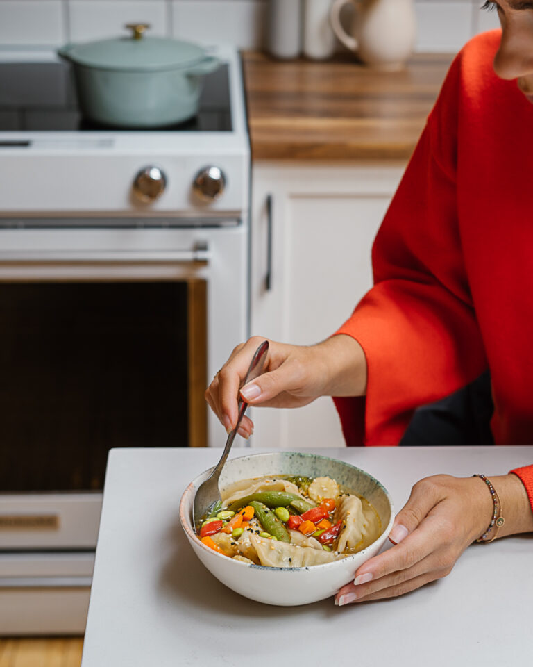 marie-eve caplette qui mang eine soupe dumpling sur un comptoir de cuisine