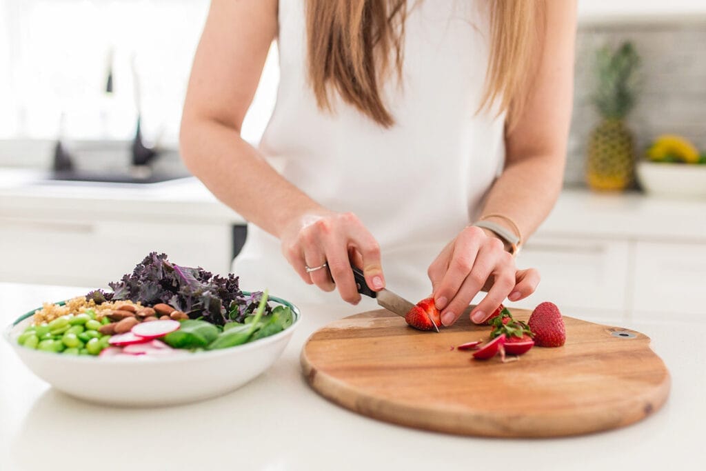 marie-eve qui coupe des légumes dans la cuisine pour simplifier les repas de la semaine