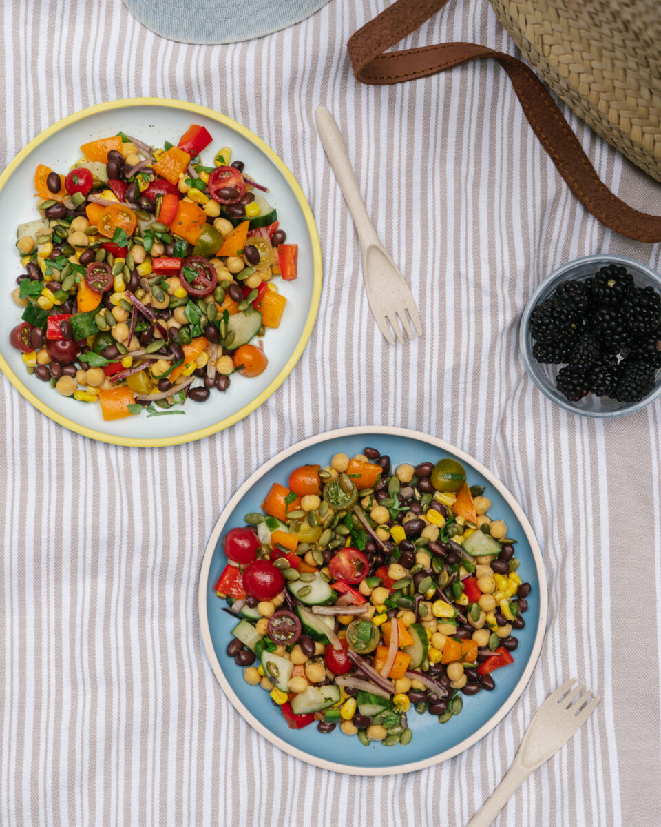 vue de haut de 2 Bols de salade de pois chiches fraîche avec haricots rouges, maïs, tomates et poivrons en pique-nique
