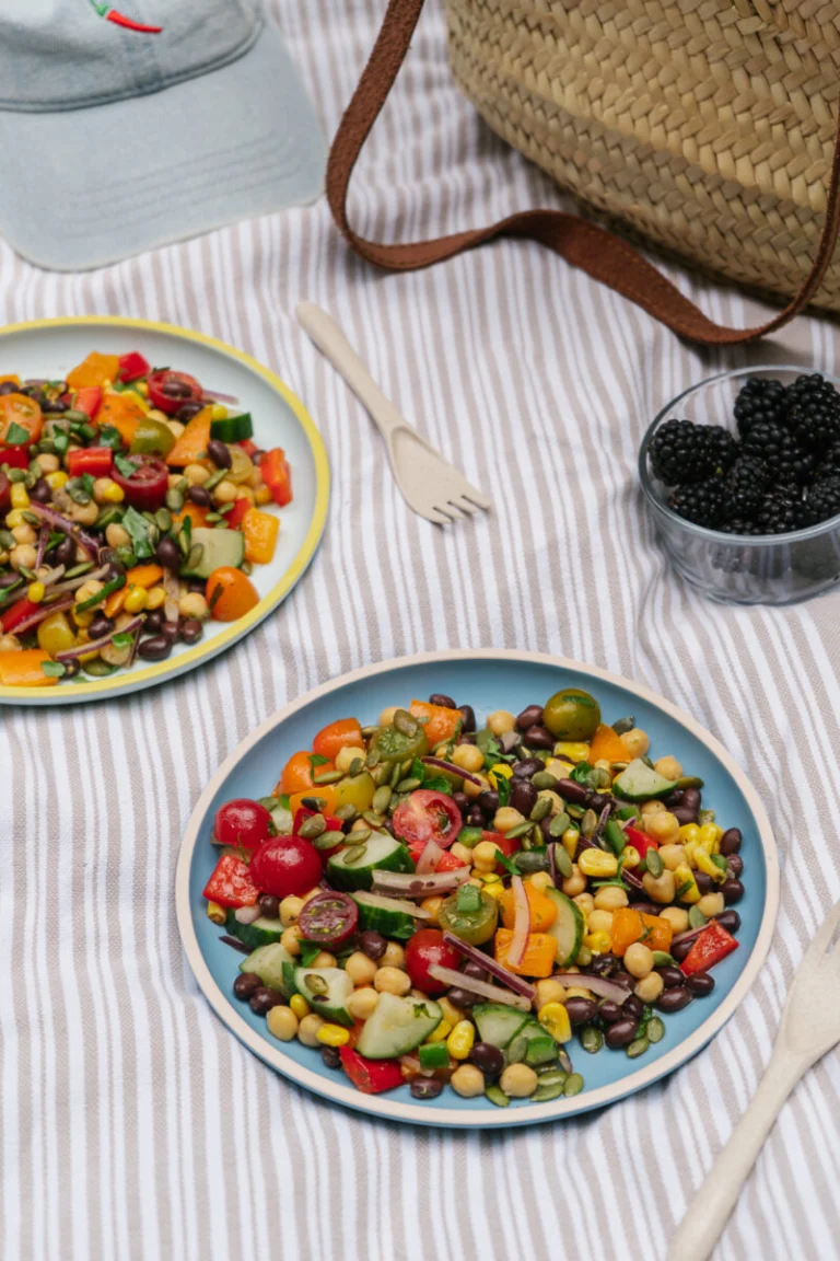 Gros plan d'une salade de pois chiches garnie de légumes colorés, d'avocat et de coriandre fraîche en mode lunch pique-nique