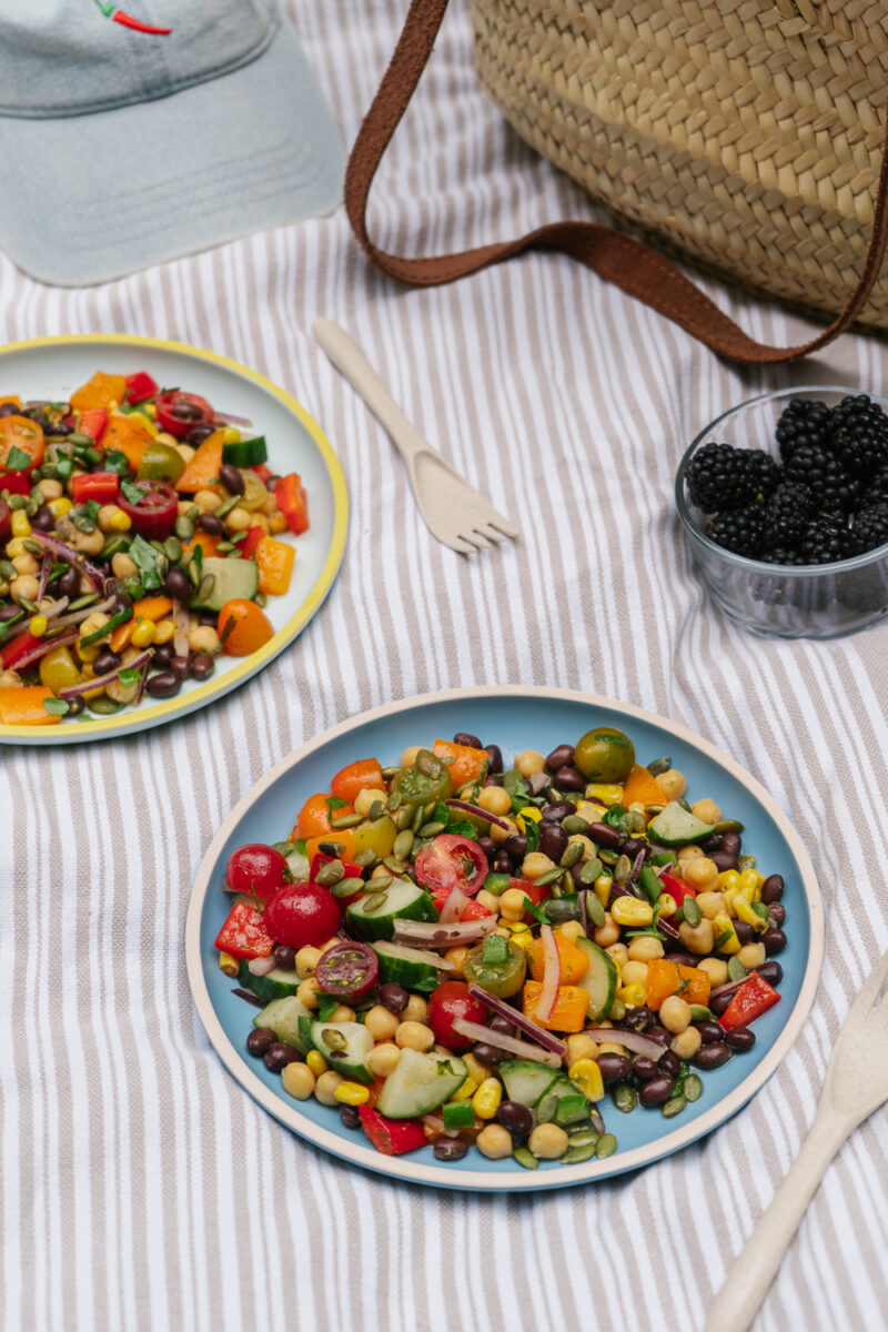 Gros plan d'une salade de pois chiches garnie de légumes colorés, d'avocat et de coriandre fraîche en mode lunch pique-nique