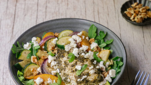 poulet au pesto sur la plaque avec courgettes et pêches grillées, servies dans un bol avec feta. recette de semaine facile sur la plaque